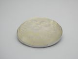 une assiette blanche sur laquelle est représenté un visage, posée sur une surface blanche
