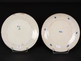 pair of blue and white plates on stands on a black surface
