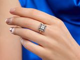 an image of a woman in a blue dress holding a diamond ring