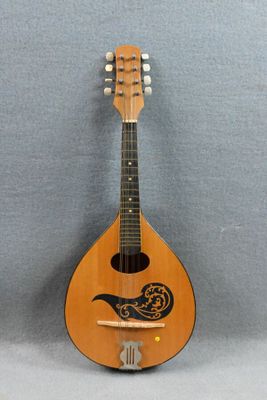 une vieille mandoline ornée d'un oiseau, posée sur une table