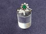 a ring with a green stone in it sitting on a glass