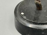 un petit objet métallique posé sur un socle noir