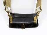 an old black and gold purse with a leather strap on a white background