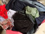 a pile of clothes in a suitcase on the floor