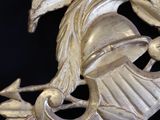 a gold clock with a bird on it on a table