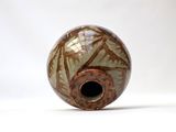a close up of a vase on a white surface