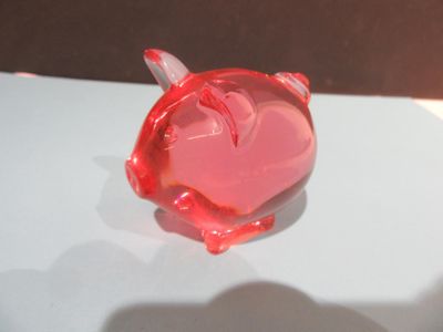une tirelire rouge posée sur une table blanche