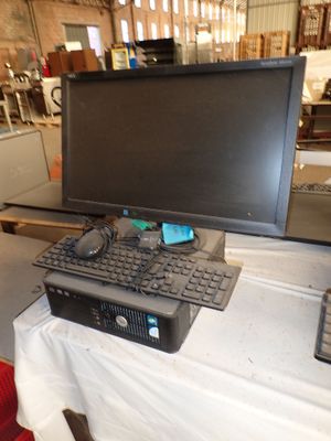 un ordinateur posé sur une table, avec un clavier et un écran