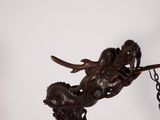 a statue of a mermaid on a chain hanging from a wall
