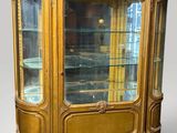 une vitrine ancienne avec des portes vitrées et des garnitures dorées