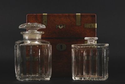 pair of antique glass decanters with wooden box on black background