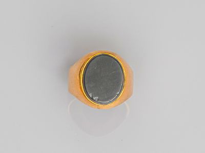 gros plan d'une bague en or avec une pierre noire