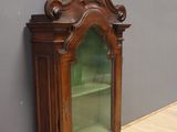 une vieille armoire en bois avec une porte vitrée, dans une pièce
