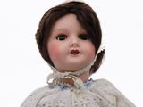 a close up of a doll wearing a white dress
