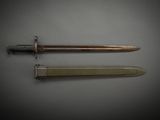 an old dagger and a knife on a gray surface