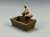 figurine en bronze représentant un chien et un canard dans un bol