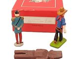 two figurines of men standing next to a box of chocolate