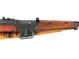 un fusil sur fond blanc, avec des coupures de presse sur le côté
