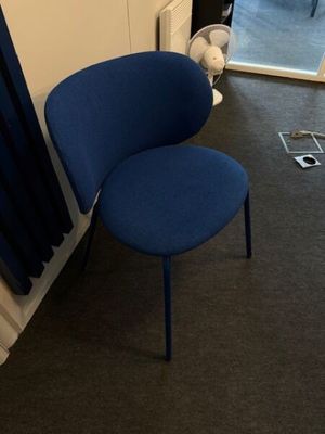 a blue chair sitting in front of a window in a room
