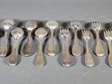 many spoons and forks laid out on the table
