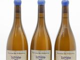 trois bouteilles de vin posées les unes à côté des autres sur une surface blanche