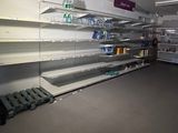 many empty shelves in a store with water bottles on them