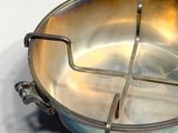 a metal bowl with four sections in it on a white surface