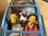 three figurines of people riding in a blue car