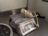 un squelette assis sur une table, à côté d'une horloge