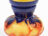 a blue and yellow vase sitting on a white surface