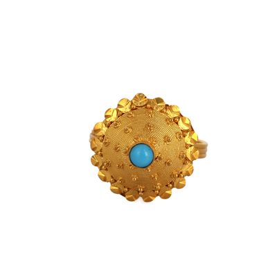 gros plan d'une bague en or avec une pierre turquoise