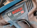 a corded drill in a box with other tools in it