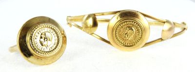 pair of gold tone cufflinks with a lion emblem
