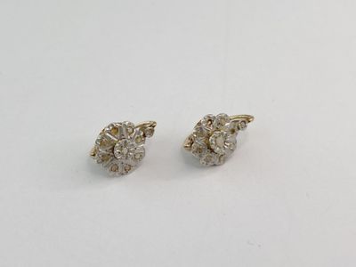 une paire de boucles d'oreilles en diamant sur une surface blanche
