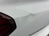 a close up of a white car with a red tail light