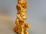 a gold figurine of a monkey sitting on a table
