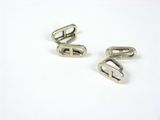 pair of silver metal buckles on a white surface