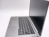 a silver laptop with a black keyboard on a white surface