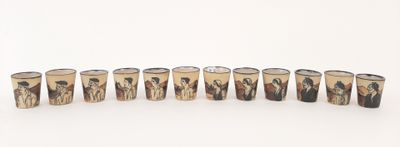 several shot glasses with different designs are lined up on a white surface