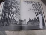 un livre ouvert sur lequel figure une photo en noir et blanc d'un château
