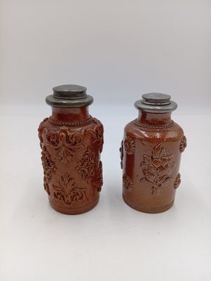 deux vases bruns posés l'un à côté de l'autre sur une table