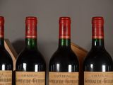 three bottles of red wine are lined up on a shelf