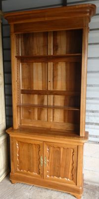 une armoire en bois surmontée d'une étagère à livres