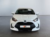 the front view of a white toyota yaris parked in a showroom