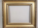 a gold picture frame on a white wall with a white background