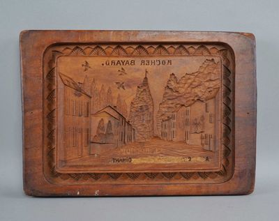an old wooden plaque with a picture of a town on it
