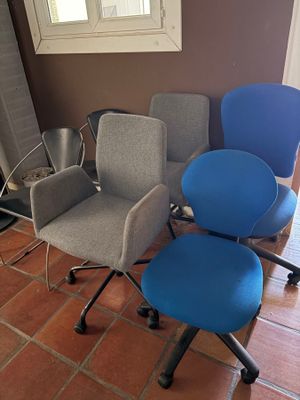 three office chairs are lined up in a row in front of a window