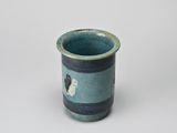 a small blue cup with a black and white dog on it