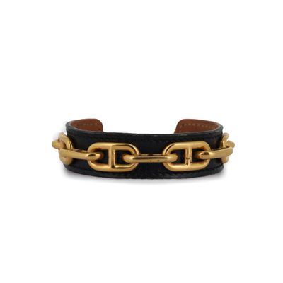 un bracelet en cuir noir orné de chaînes dorées et d'un fermoir doré