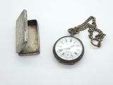 une montre de poche en argent avec une chaîne autour d'elle
